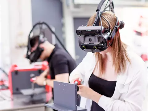 Zwei Personen lernen mit dem Welducation Simulator zu schweißen.