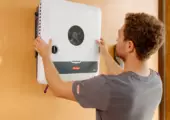 Installateur montiert Fronius Wechselrichter